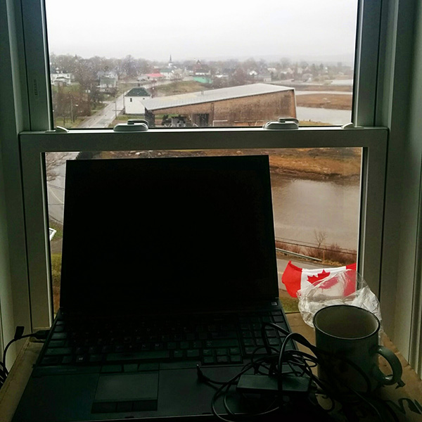 a photo of my laptop set up looking out the window of my old house