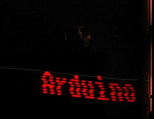 The word "Arduino" is illuminated by red LEDs in a blur.