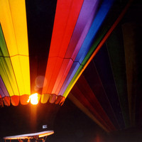 An image of a hot air balloon, its flame glowing in the dark scene.