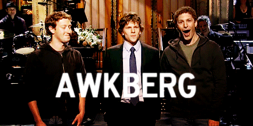 An animated gif of a comedy stage with Mark Zuckerberg on the left, Jesse Eisenberg in the middle, and Andy Samberg in the middle. Samberg is mouthing 'awkberg' while that word flashes in the front in big text.