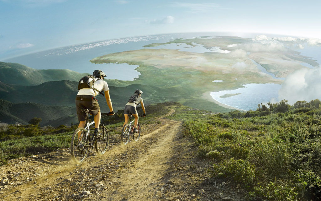 an image of a couple biking down a mountain. the image is distorted so that you can see the entirety of africa and europe before the horizon, and the curve of earth's globeness in the background